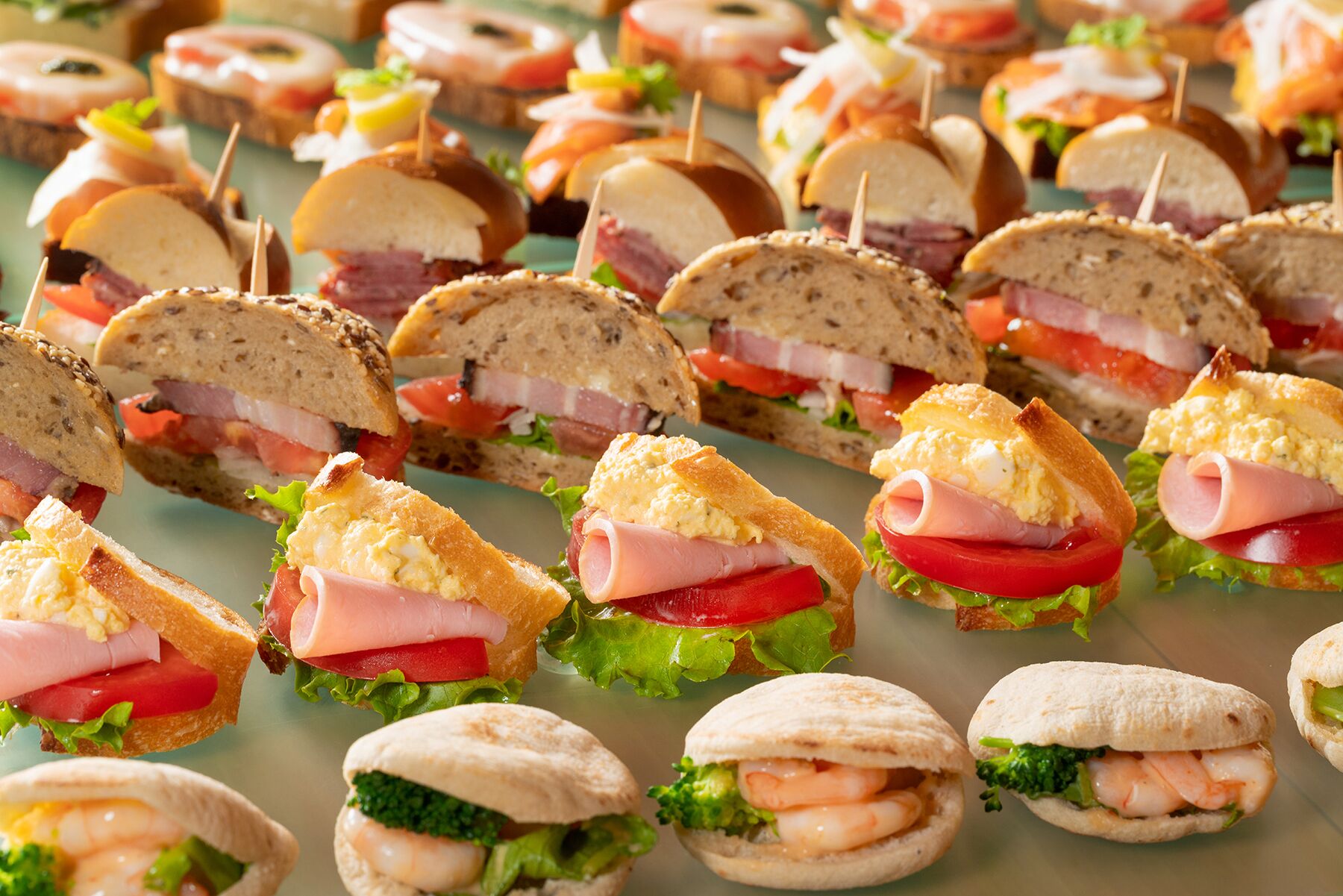 Verschiedene Sandwiches und Vorspeisen sind auf einem Tisch angerichtet.