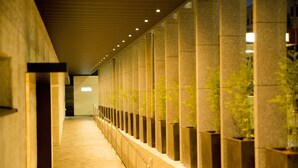 A corridor with a series of columns and potted plants. - Sakura Terrace (Kyoto)