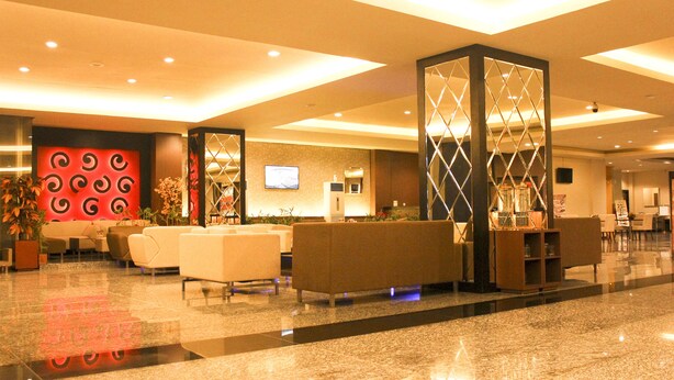 A spacious lobby with a modern design, featuring a reception desk, seating areas, and decorative elements. - Grand Asia Hotel (Makassar)