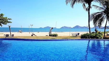 Una piscina al aire libre, sillones reclinables de piscina