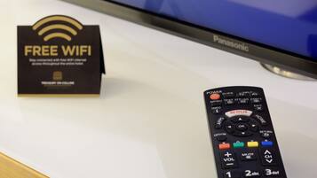Un televisor Panasonic, un control remoto y un cartel que indica 'Free WiFi'.