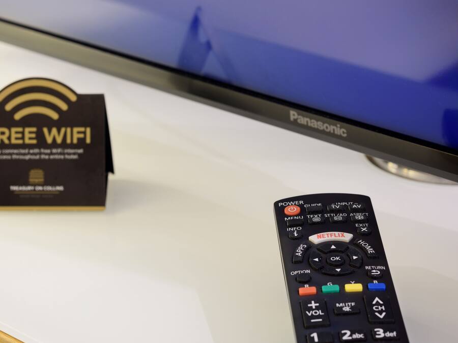Un televisor Panasonic, un control remoto y un cartel que indica 'Free WiFi'.