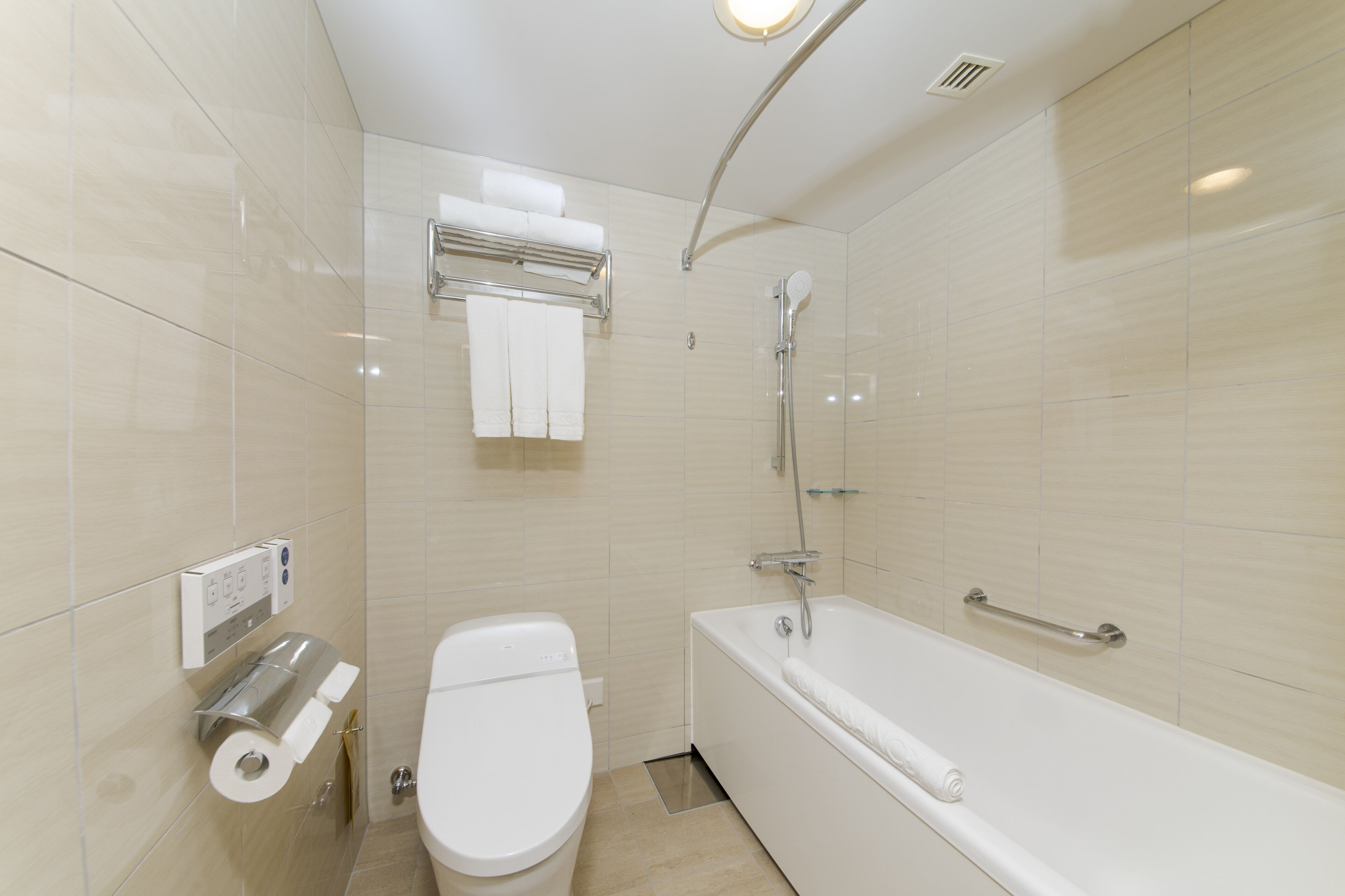 A modern bathroom with a toilet, a shower, and a bathtub.