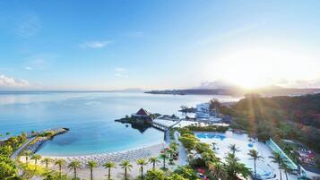 A resort with a beach, pool, and pier.