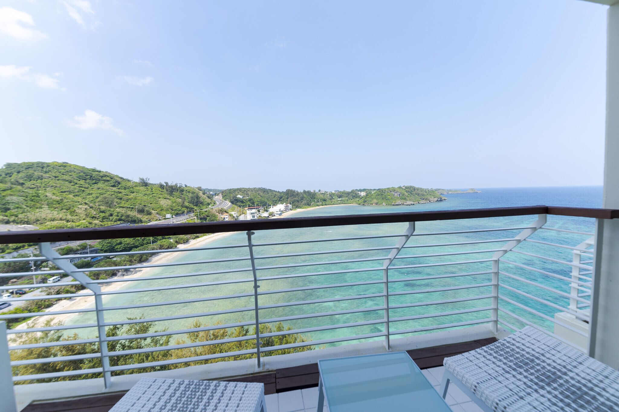 A balcony with a view of a beach and ocean.