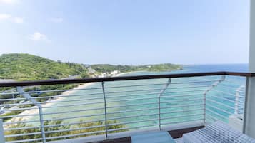 A balcony with a view of a beach and ocean.