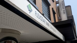 Une enseigne d’hôtel portant le nom « FLEXSTAY INN Shingawara ».
