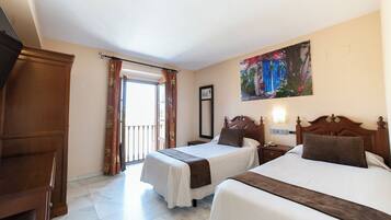 Habitación de hotel con dos camas, un armario de madera, un cuadro en la pared y vistas al exterior.