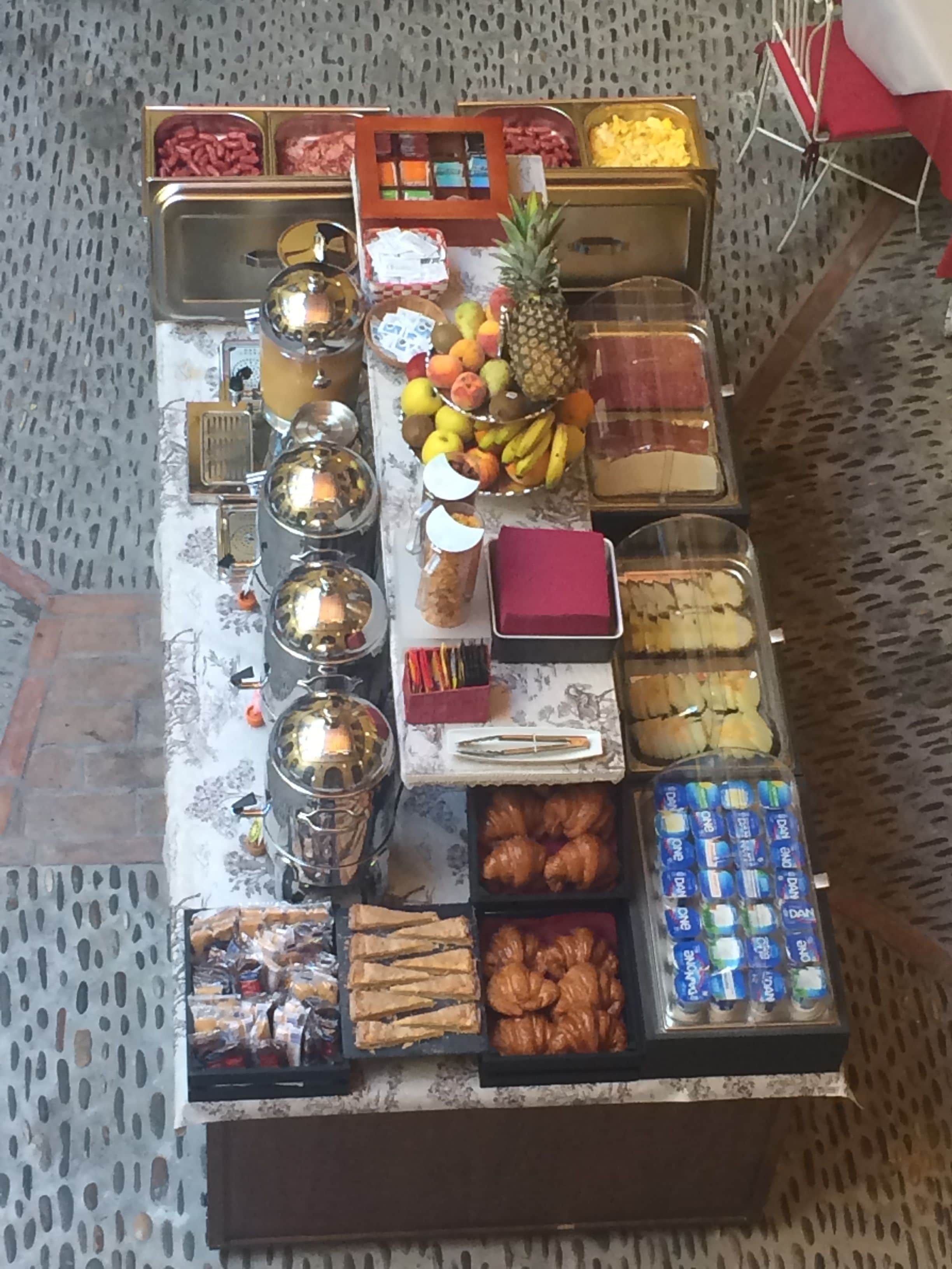 Een buffet met diverse soorten eten, zoals fruit, gebak en sauzen.