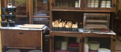 Un área de cocina con muebles de madera, una cafetera y diversos utensilios.