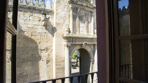 Un bâtiment en pierre doté d’un portail orné et d’un balcon.