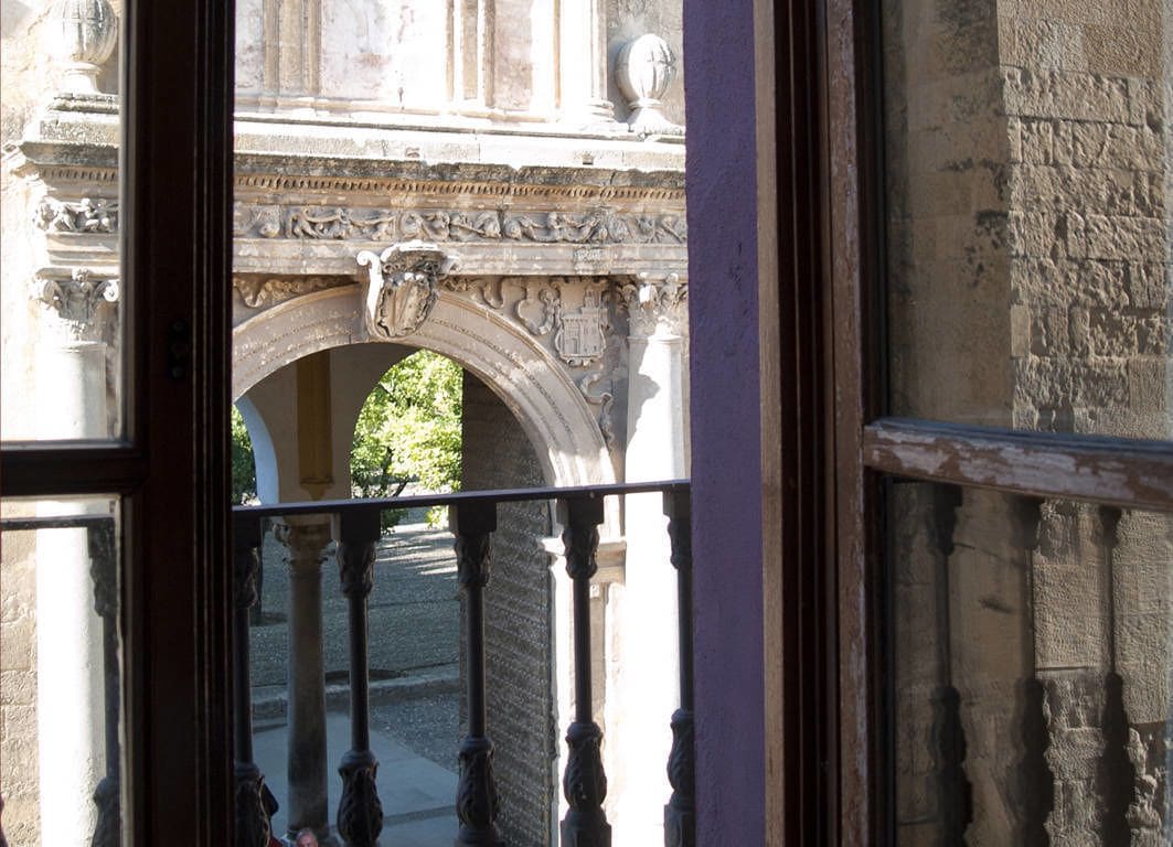 An ornate stone archway with intricate carvings and a balcony railing.