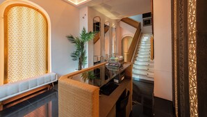 Un interior moderno con una escalera, un banco y un muro decorativo.
