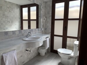A modern bathroom with a large sink, a toilet, and a shower area. - Hotel la Chiquita (Córdoba)
