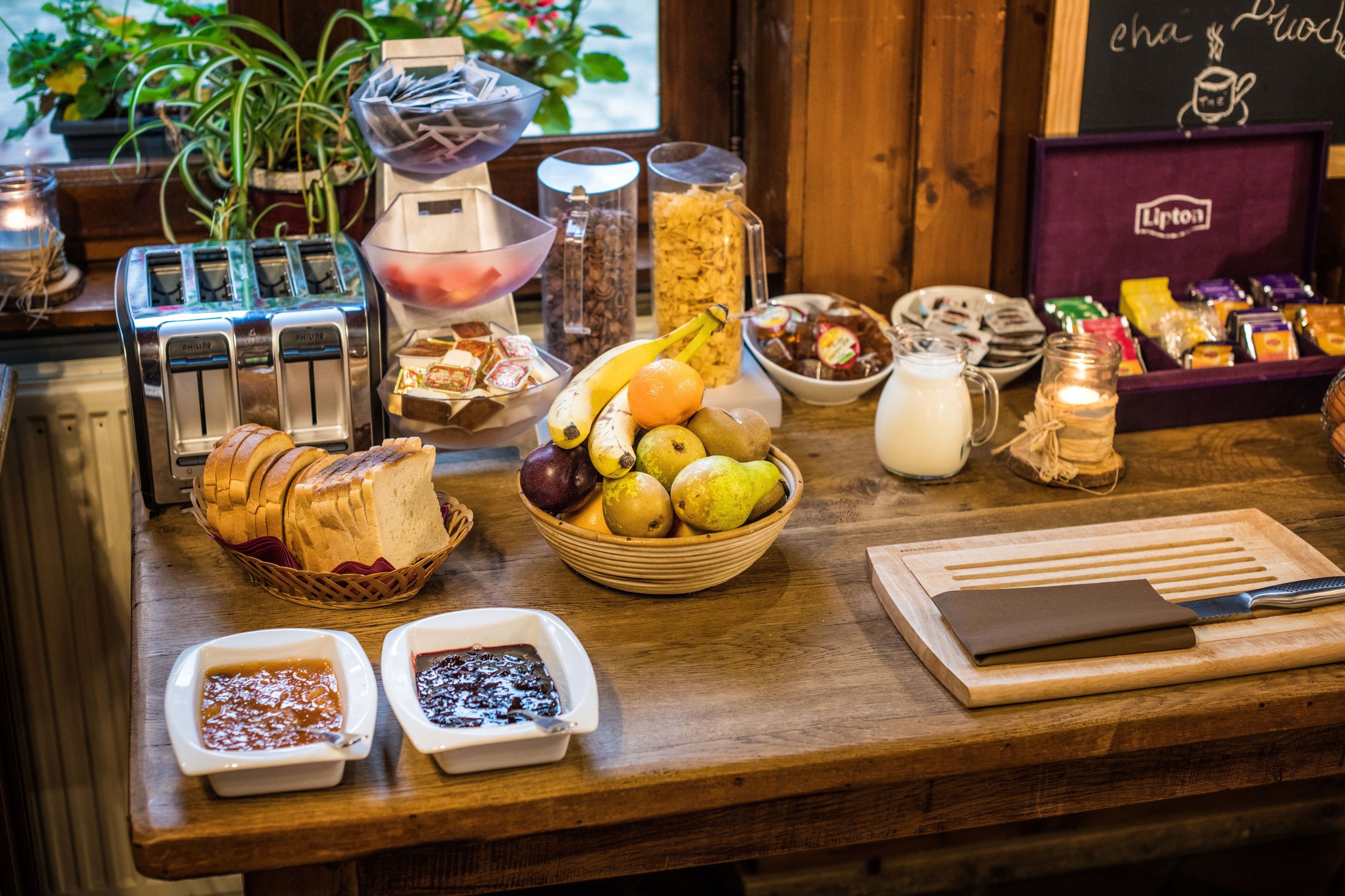 Un buffet de petit-déjeuner proposant une variété de fruits, de pains et de condiments.