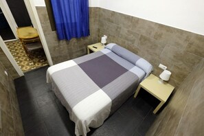 A small, neatly arranged bedroom with a bed, two bedside tables, and a chair. - Lenin Hostel Barcelona (Barcelona)