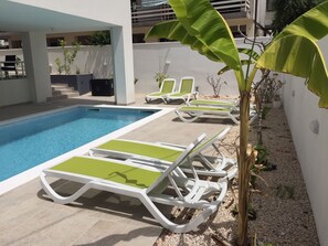 Una piscina al aire libre de temporada, sombrillas