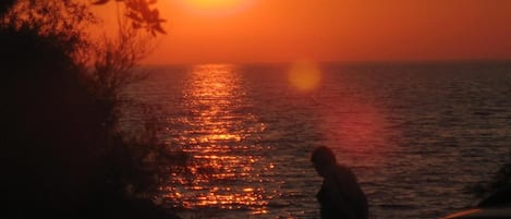Atardecer sobre el océano, con la silueta de una persona.