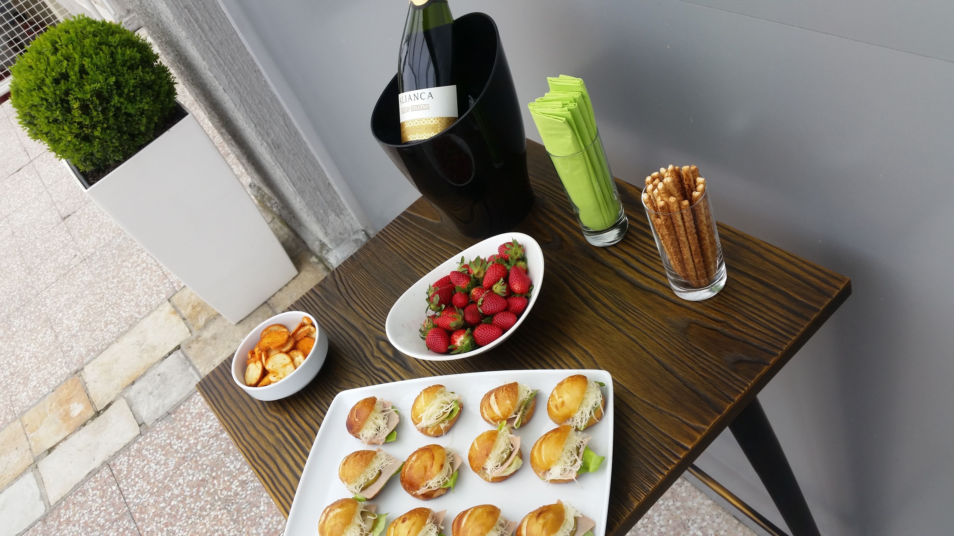 A table with snacks, a bottle of wine, and a glass of water.