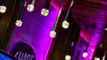 Una fila de micrófonos con un fondo iluminado en morado y un letrero que dice 'SHARE EVENTS'.