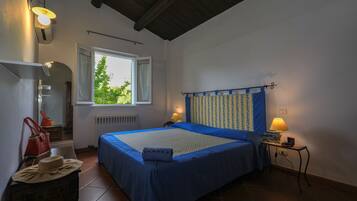 Un dormitorio con cama, lámparas de noche, mesita de noche, ventana y cómoda.