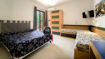 A bedroom with a large bed, a smaller bed, a wardrobe, a TV, and a desk.