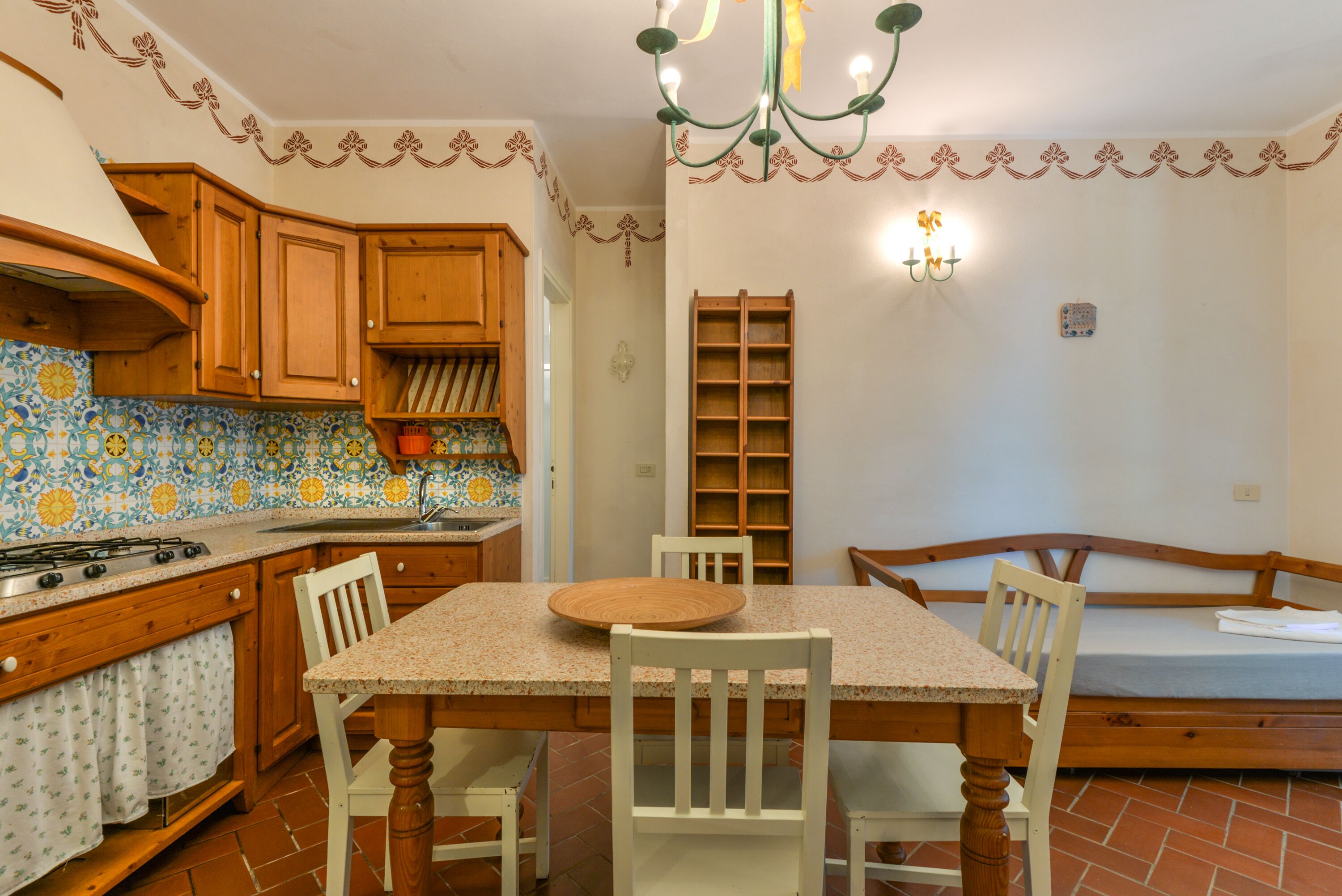 Una cocina con armarios de madera, una estufa y una mesa de comedor con sillas.