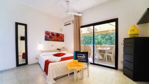 Habitación de hotel con cama, una silla con toalla, escritorio, espejo y vistas al exterior.