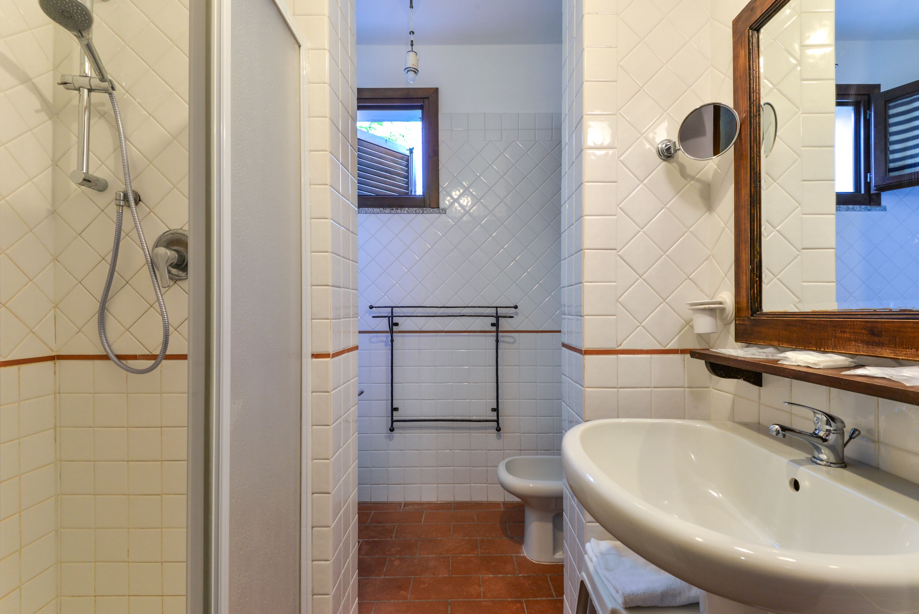 A bathroom with a shower, toilet, and sink.