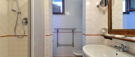 A bathroom with a shower, toilet, and sink.