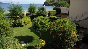 Un jardín con vistas al mar, un sendero y un edificio con balcón.
