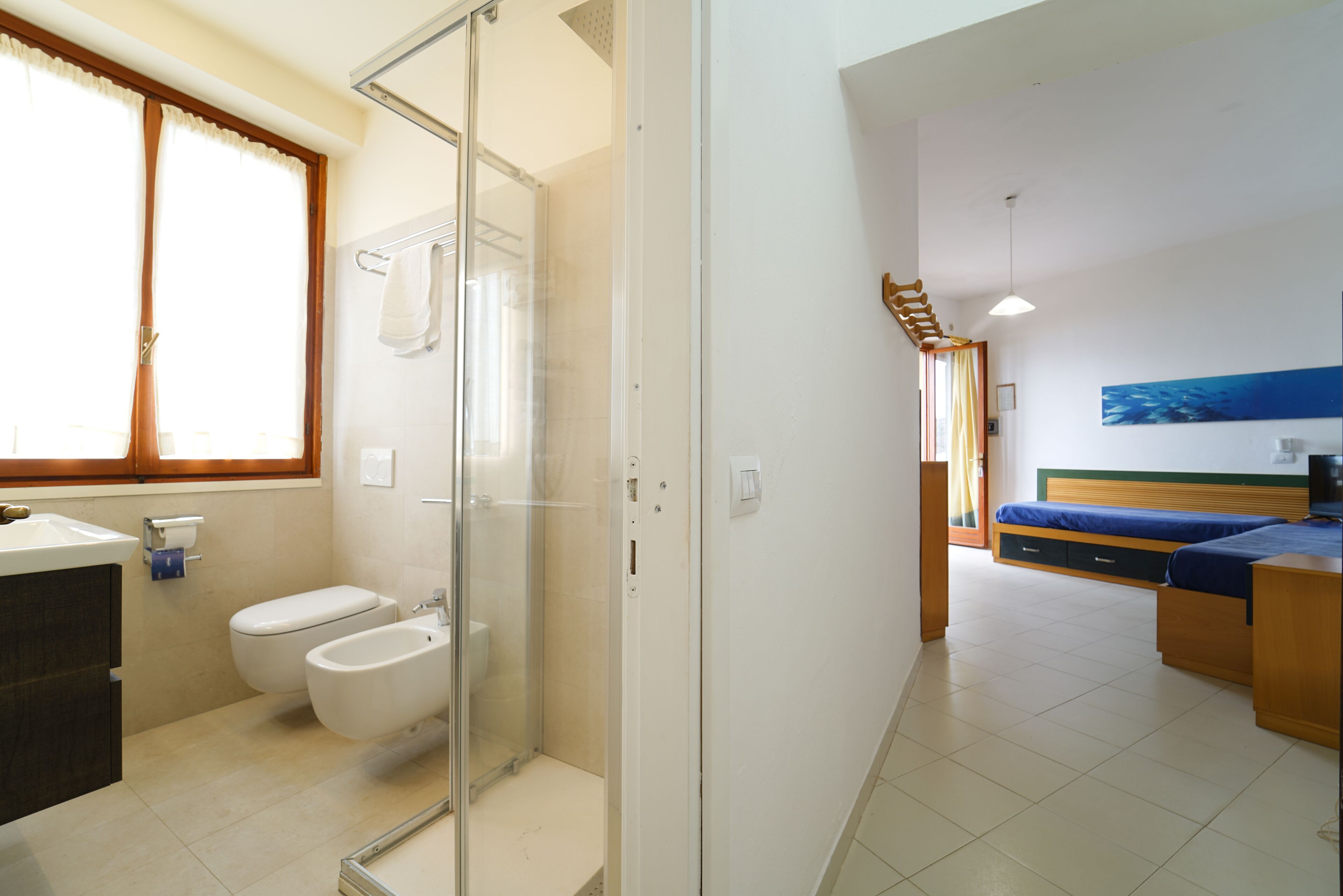 Un bagno moderno con cabina doccia in vetro, un water e un bidet.