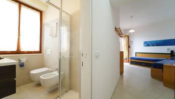Un bagno moderno con cabina doccia in vetro, un water e un bidet.