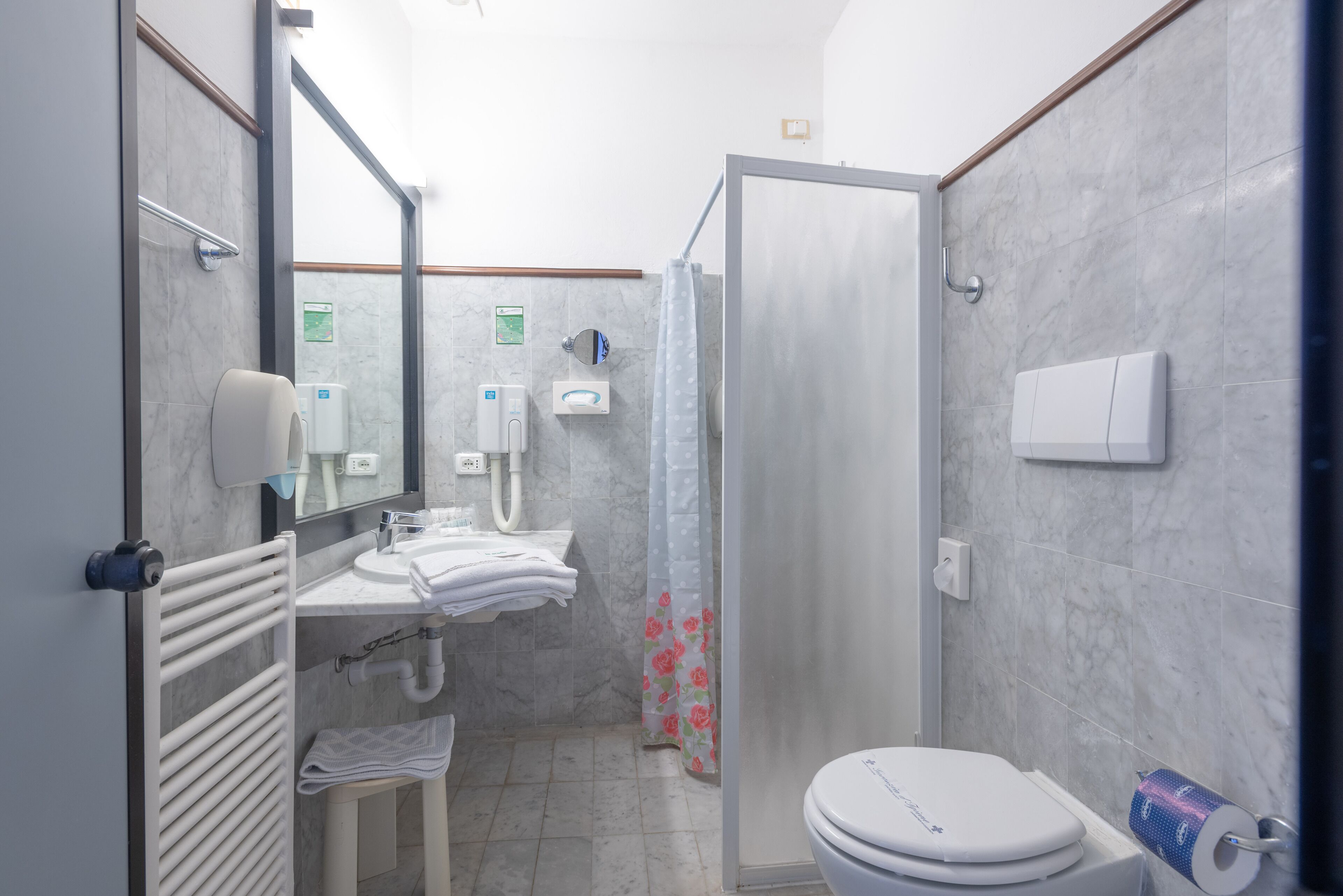 Un baño con inodoro, lavabo y ducha.