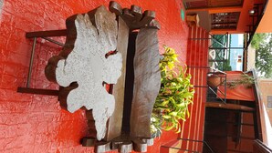 A red brick wall with a large, abstract metal sculpture in the center. - Terra Iguazú Apart Hotel (Puerto Iguazú)