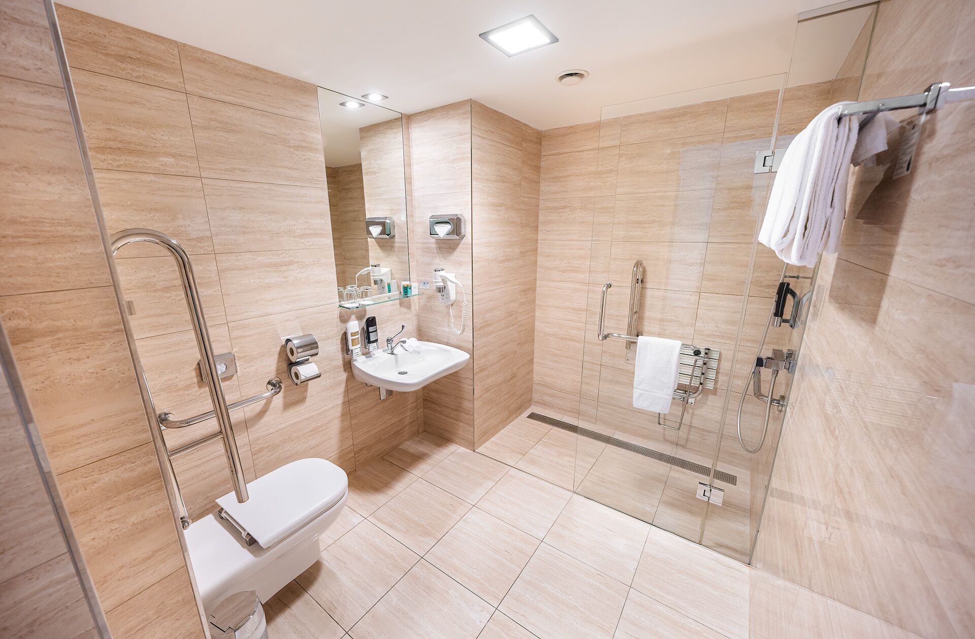 A modern bathroom with a glass-enclosed shower, a toilet, and a sink.