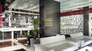A modern interior with a white sofa, a Nespresso station, and a display of various items.