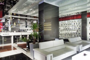 Um interior moderno com um sofá branco, uma estação Nespresso e uma seleção de objetos decorativos.