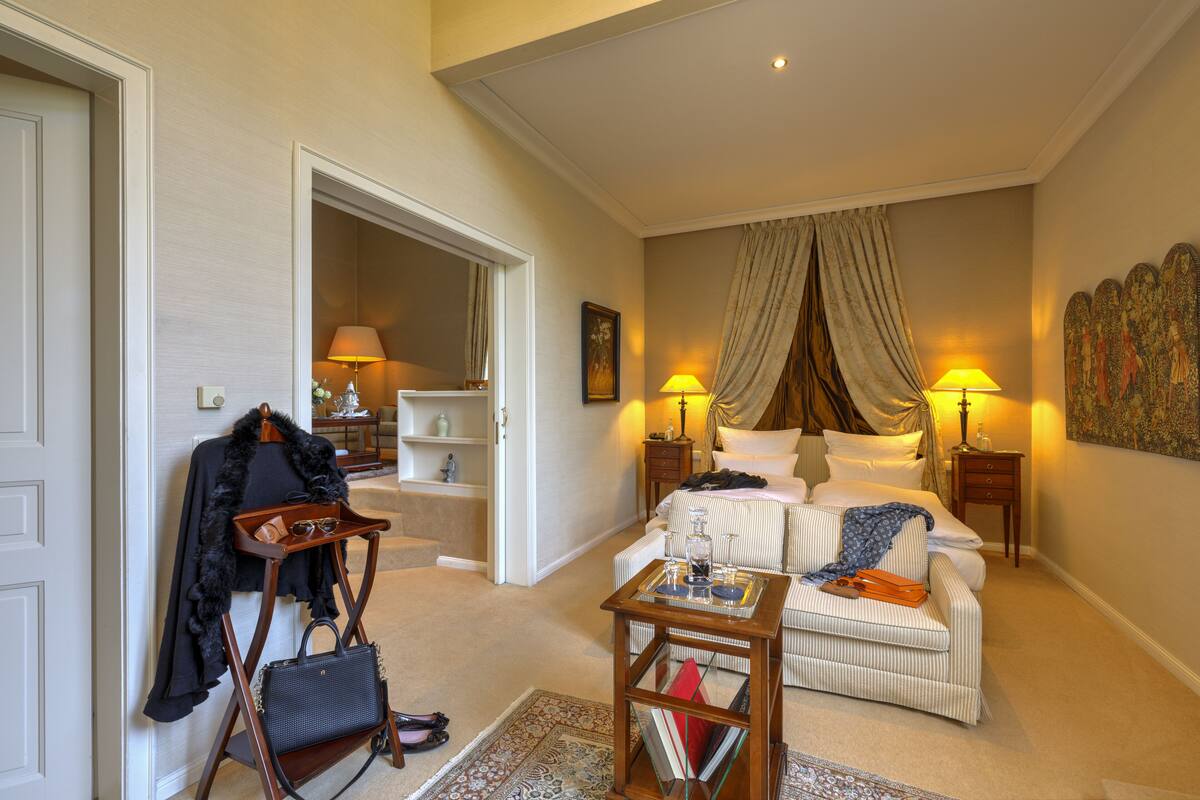 Een hotelkamer met een bed, een bank, een kleine tafel en een kapstok.
