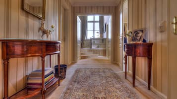 Ein Flur mit einem Holztischchen, einem Teppich und einer Treppe, die zu einem Zimmer führt.