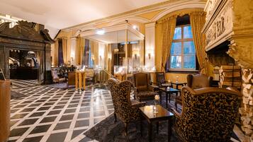 A luxurious room with a checkered floor, ornate furniture, and a fireplace.