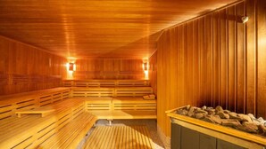 A sauna with wooden benches and a stone basin. - Strandresidenzen Binz (Binz)