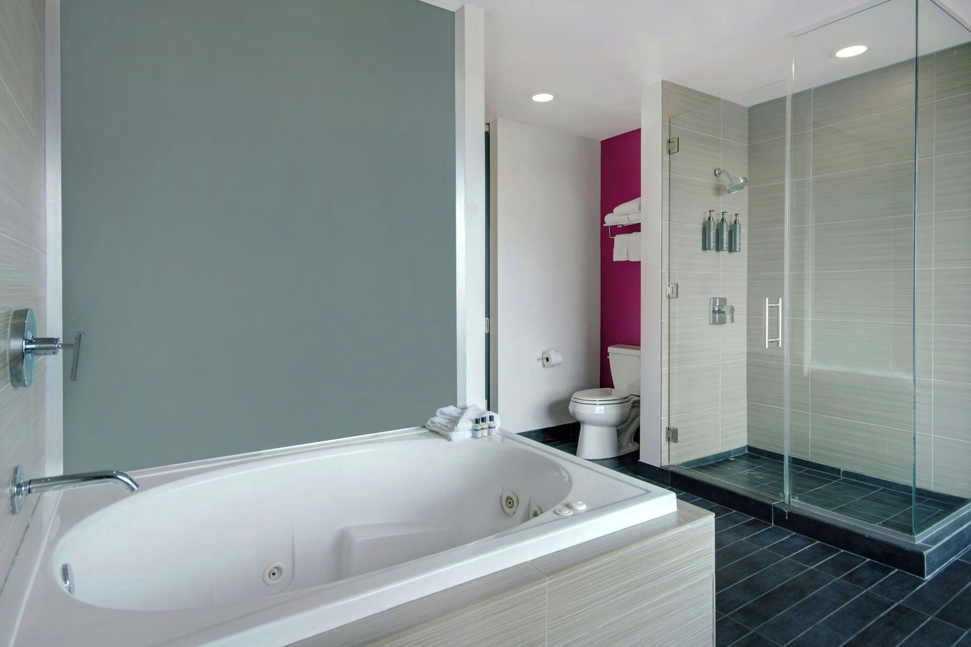 Ein modernes Badezimmer mit einer freistehenden Badewanne, einer Duschkabine und einem WC.