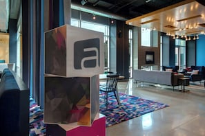 A modern interior with a reception desk, seating area, and a colorful geometric wall art installation.
