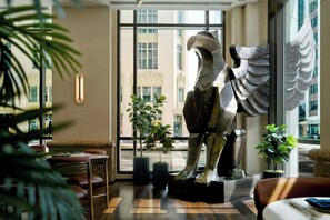 A modern interior with a large sculpture, seating area, and large windows. - JW Marriott Houston Downtown (Houston)