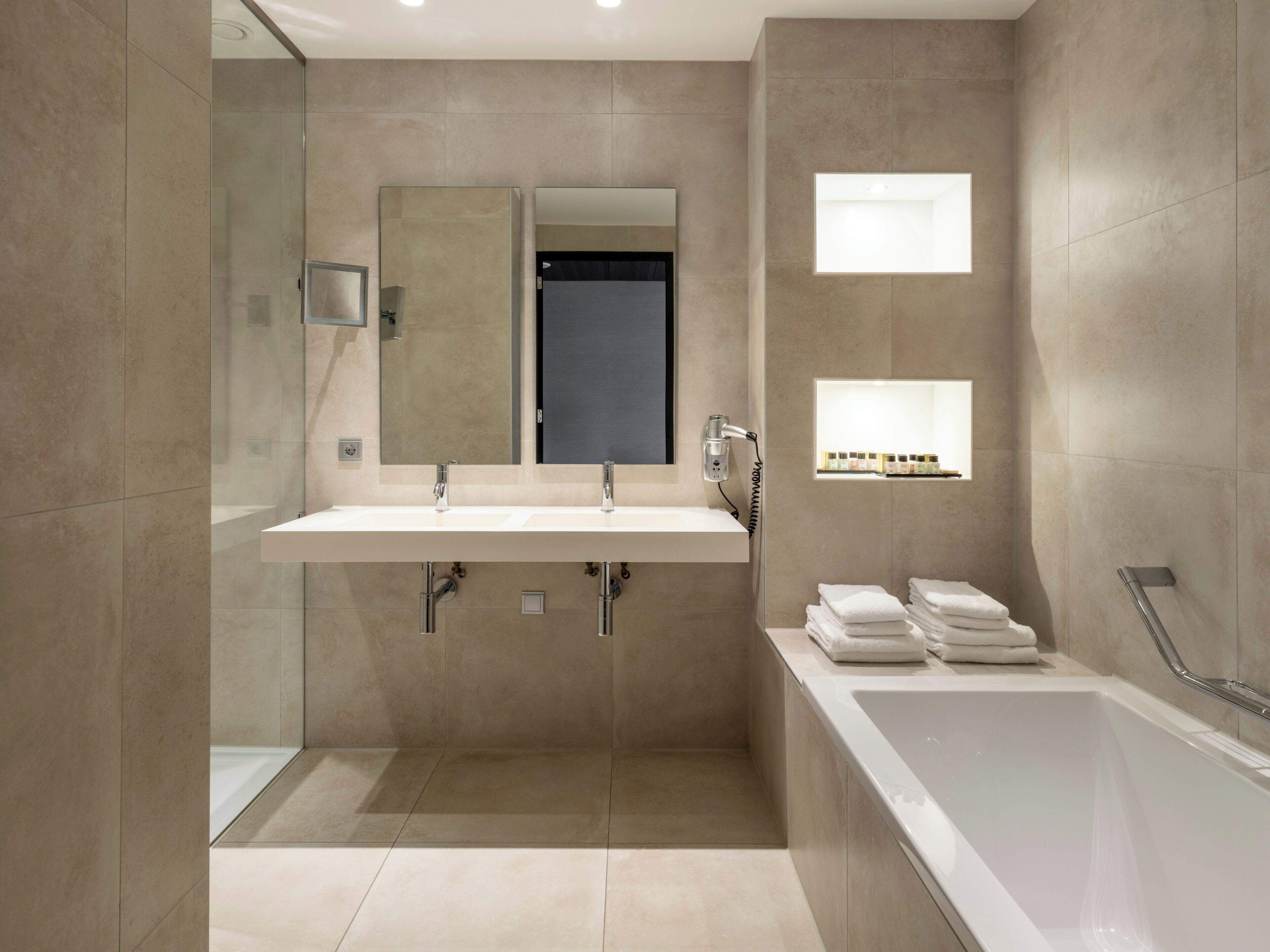 Un baño moderno con un lavamanos grande, un espejo, una ducha y una bañera.