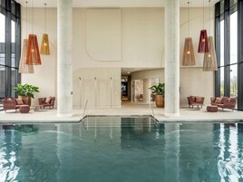 Una piscina techada, sillones reclinables de piscina