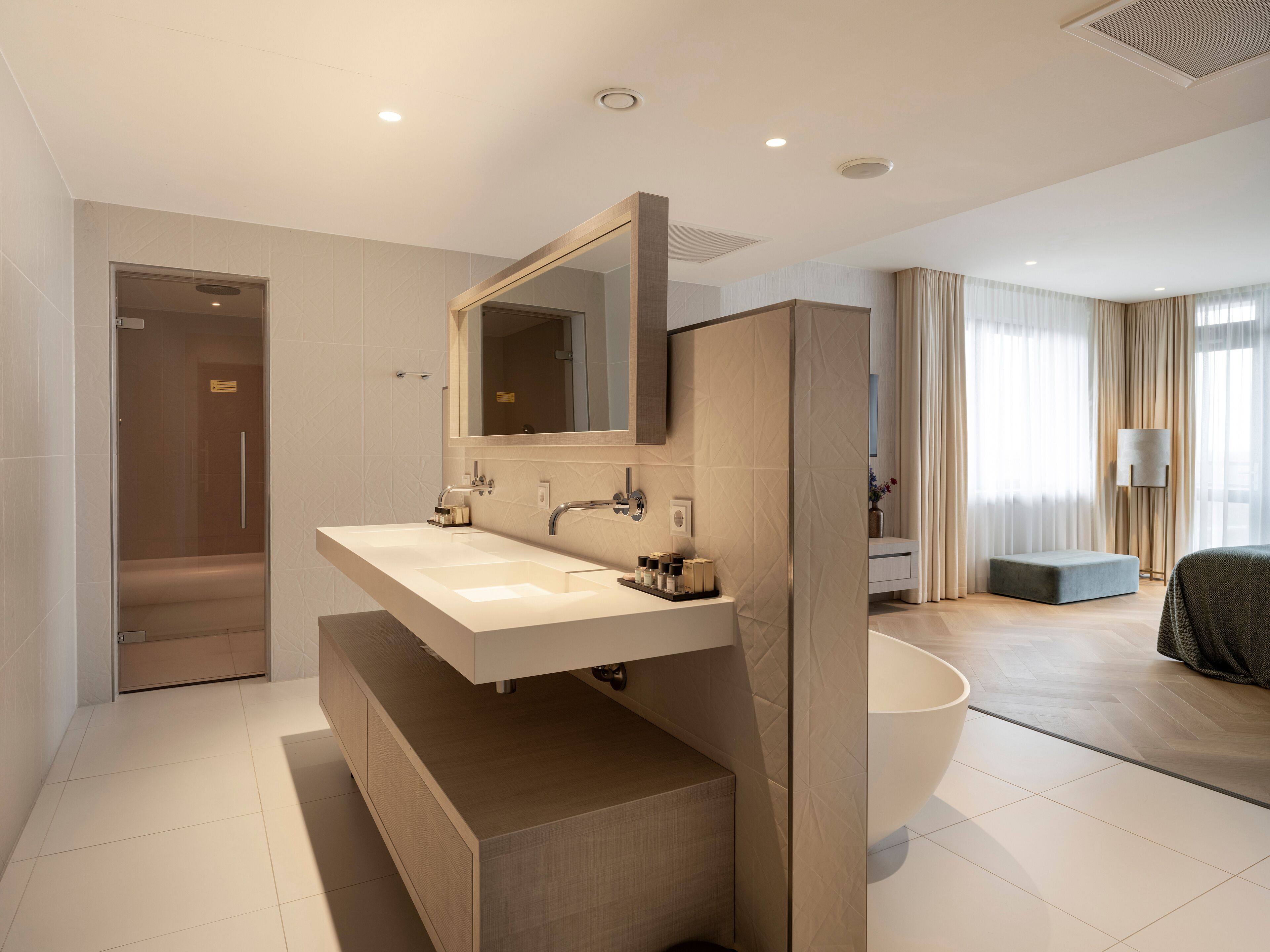 A modern bathroom with a large sink, mirror, and bathtub.