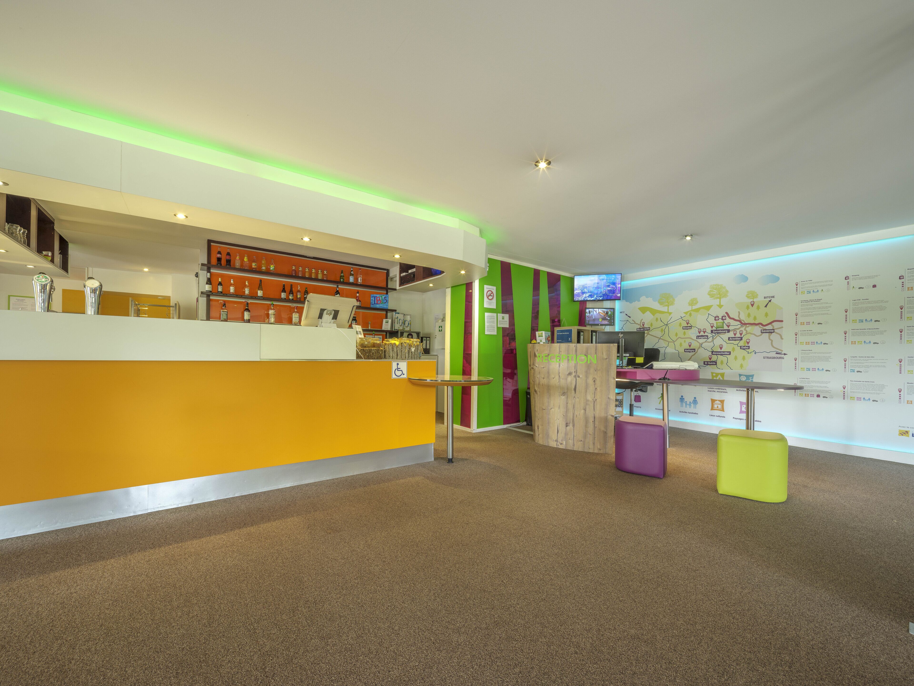A reception area with a counter, a television, and informational posters on the wall.