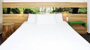 Une chambre à coucher avec un lit, une tête de lit en bois, un banc vert et une table de chevet en bois.